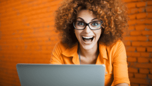 An exuberant woman on her laptop who has an unhealthy love affair with Microsoft Excel