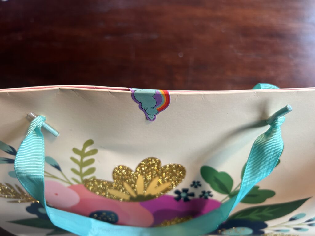 Demonstration of how to seal a gift bag using a sticker