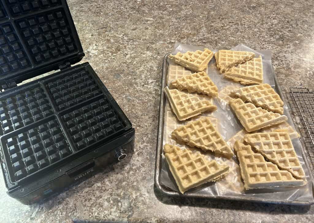 Waffles fresh out of the waffle maker and ready to be frozen on a cookie sheet
